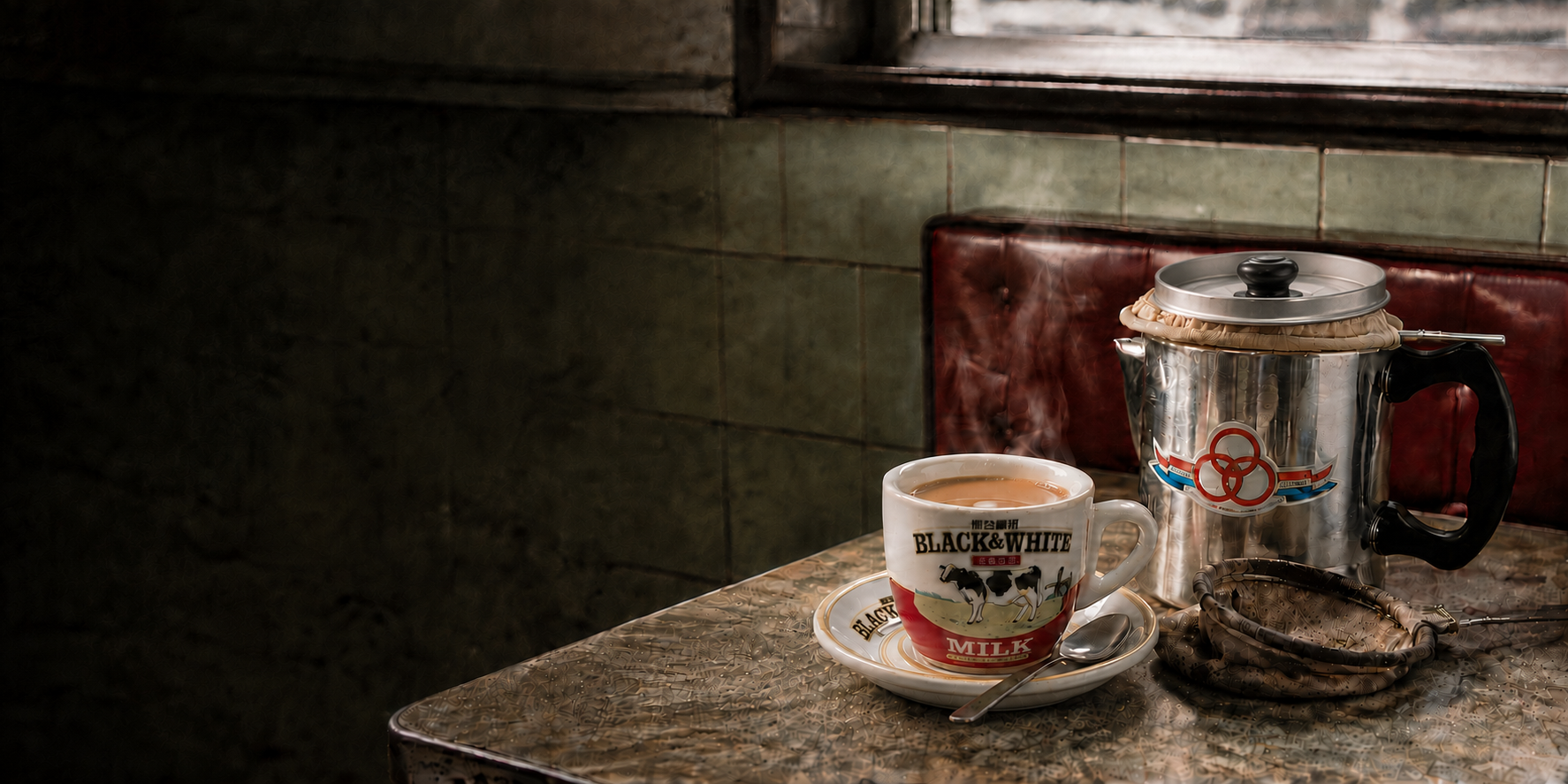 A classic ceramic cup of Hong Kong milk tea beside a Rings Brand (三元牌) tea pot and cloth filter in a cha chaan teng